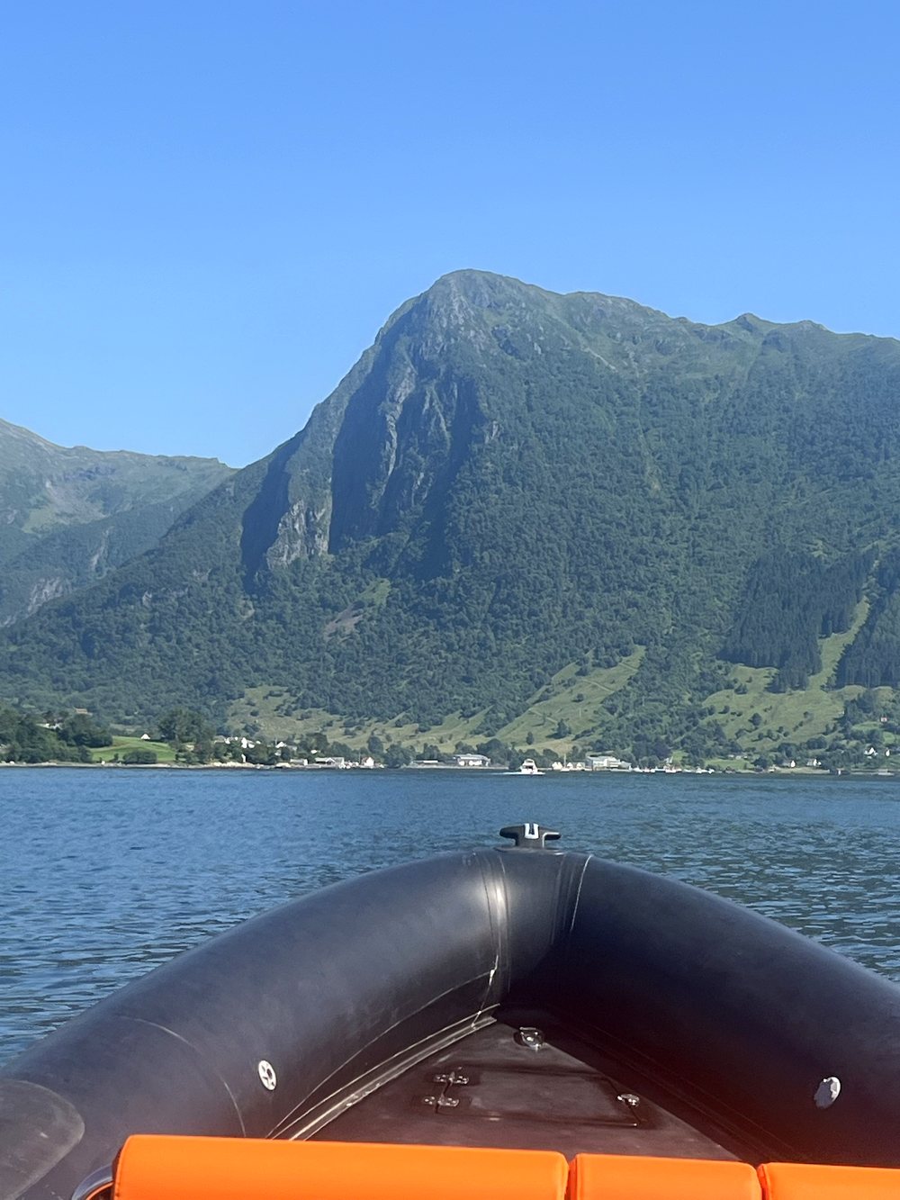 View from the bow of the RIB towards a fjord mountain